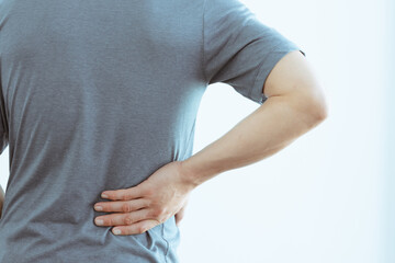 asian man with lumbar pain, backache and massage on waist to pain relief.
