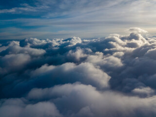 Aerial high flight above the clouds at sunrise.