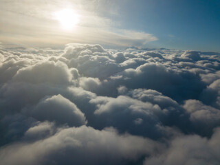 Fototapeta premium Aerial high flight above the clouds at sunrise.