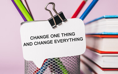 Text Change one thing and change everything on a white sticker with office stationery background. Flat lay on business, finance and development concept