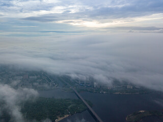 High view of the Dnieper River in Kiev. Aerial high flight above the clouds.