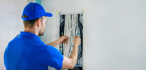 house electrical wiring - electrician working with cables in junction box. banner copy space