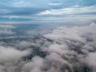 Fototapeta na wymiar City under the clouds at dawn. Aerial high drone view.