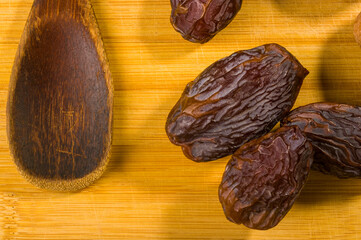 Big luxury dried date fruit on the wooden board, kurma ramadan kareem concept, close up.
