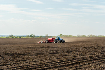 A tractor cultivating field at spring morning.