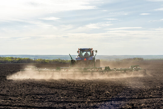 A Tractor With Cultivator Plowing On Morning.