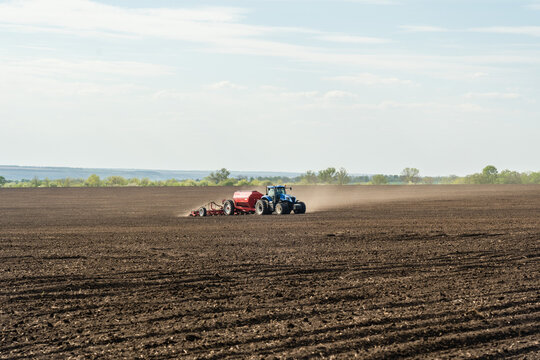 A Tractor With Cultivator Plowing On Morning.