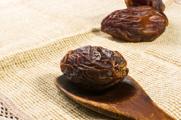 Big luxury dried date fruit on a linen napkin, kurma ramadan kareem concept, close up.