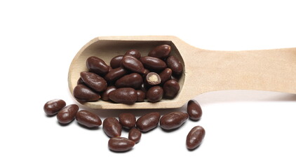Obraz premium Chocolate covered sunflower seeds with wooden spoon isolated on white background