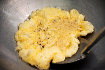 Omelet cooking in the frying pan.