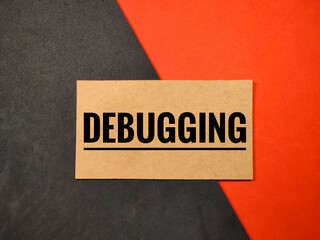 Business concept. Brown card with text DEBUGGING on black and red background
