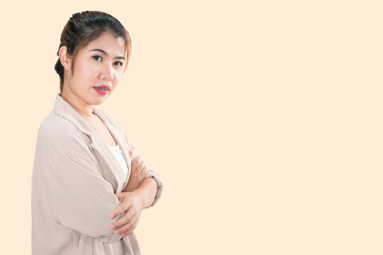 An Asian woman stands with her arms crossed and looks at the camera.