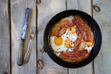 Delicious scrambled eggs with bacon. English breakfast. Rustic style.