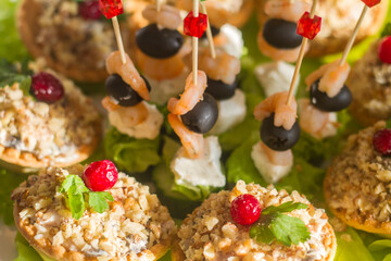 snacks on the festive table on skewers and in tartlets