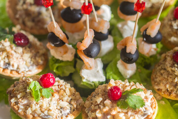 snacks on the festive table on skewers and in tartlets