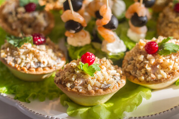 snacks on the festive table on skewers and in tartlets