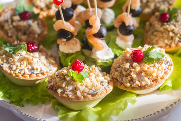 snacks on the festive table on skewers and in tartlets