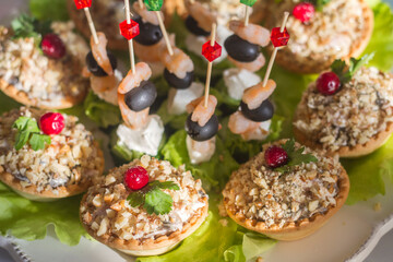 snacks on the festive table on skewers and in tartlets