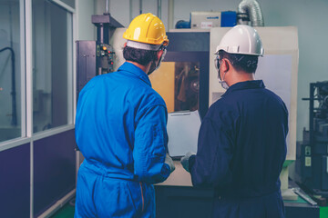 Male industrial engineer or technician worker using control machine operating control CNC machinery at factory Industrial.
