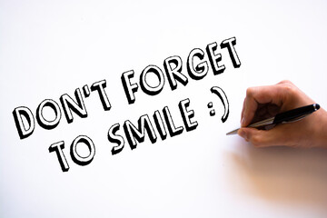 Text don't forget to smile on note paper
