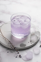Summer fresh purple non-alcoholic cocktail with lavender sprigs, ice and sparkling water. Mocktail, healthy lifestyle
