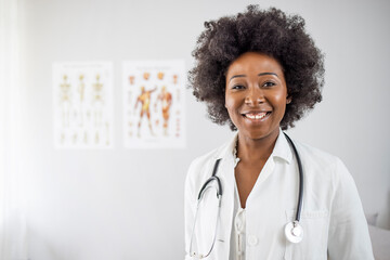 Portrait of an attractive young african-american female doctor in white coat. Portrait of glad...