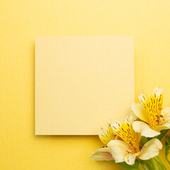 Memo pad with Alstroemeria flowers on yellow background. top view, copy space
