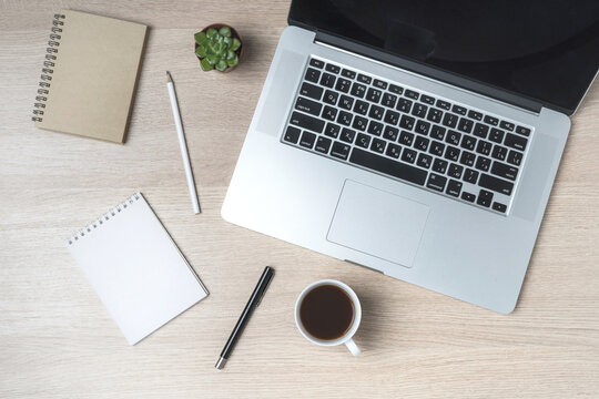 Office table with notepad, computer and coffee cup. Mockup, top view with copy space. Office desk table concept.