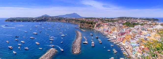 Panoramic view of beautiful of Procida, Italian Capital of Culture 2022: colorful houses, cafes and restaurants, fishing boats and yachts in Marina Corricella , in  Gulf of Naples, Campania, Italy.