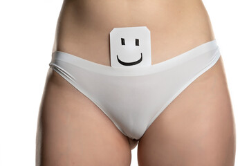 a woman in white panties and a piece of paper with a drawn smile - obrazy, fototapety, plakaty