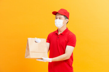 Delivery Asian man wear protective mask in orange uniform and ready to send delivering Food bag