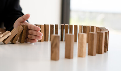 plan and strategy in business protect with balance wooden stack with hand control risk shape.