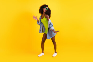 Fototapeta na wymiar Full length photo of sweet shiny dark skin lady dressed denim outfit glasses dancing isolated yellow color background