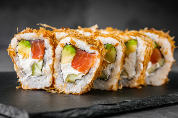 appetizing philadelphia sushi roll with tuna salmon avocado chips and cucumber on a black stone plate