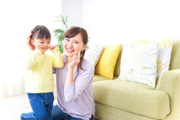 子どもの髪の毛を結ぶお母さん