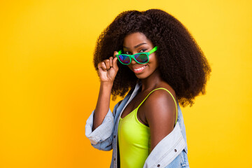 Photo portrait of young woman smiling taking-off sunglass curly hairstyle spending free time isolated vivid yellow color background