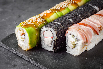 appetizing set of sushi roll on a black stone plate