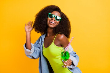Photo of pretty charming dark skin lady dressed denim outfit glasses drinking alcohol dancing isolated yellow color background