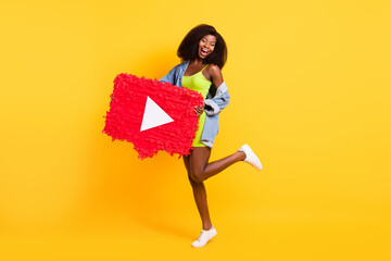 Full length body size view of attractive cheerful girl holding big video button dancing isolated over bright yellow color background