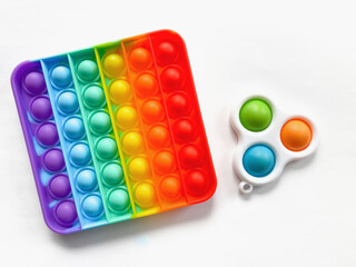 Pop it and Simple Dimple - Antistress toy isolated on a white background.  A popular soothing toy for children and adults.  Soft silicone bursting bubbles in rainbow colors.  Flat lay.