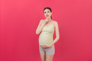 Pensive pregnant woman choosing name for baby on colored background. Dream and Happy Pregnant Woman Thinking Imagining Motherhood Life. Copy Space