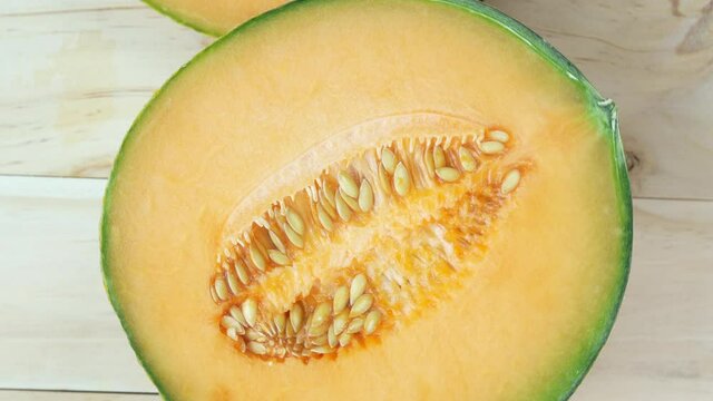 Top view Rotate of Melons  on wooden background, Yellow US melon or cantaloupe melon with seeds isolated on wooden background