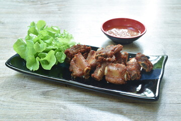 fried crispy pork bone or rib on plate dipping chili sauce cup