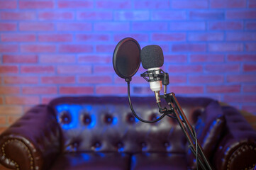 A microphone in a music studio with colorful lights.