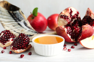 Honey, pomegranate, apples and shofar on white wooden table. Rosh Hashana holiday