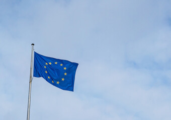 Flag of the European Union waving in the wind with a blue sky