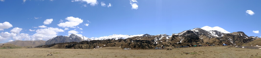 Panorama of the Caucasus mountains with a view of Elbrus and the camp of mine rescuers.