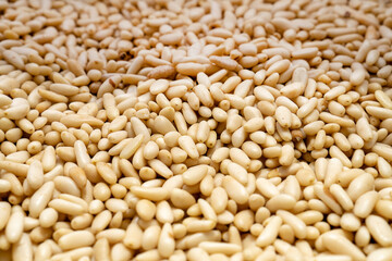 Closeup of shelled raw pine nuts. Top view blur textures soft focus
