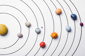 Flat lay composition with colorful stones on white background representing solar system