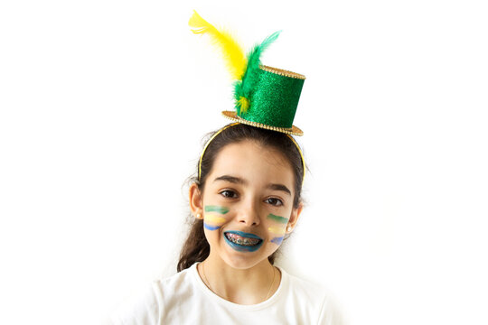 Cut Brazilian girl with painted face over white background. Soccer fan cheers. Green and yellow clothes and flag.